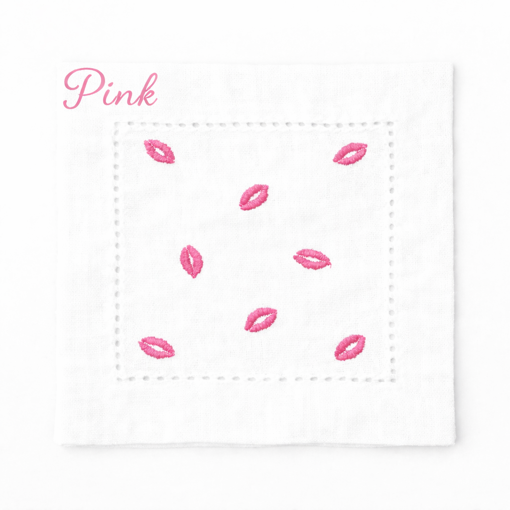 Embroidered white cocktail napkin featuring pink kiss lip design, styled for Valentine’s Day table décor, romantic dinner parties, and chic entertaining.