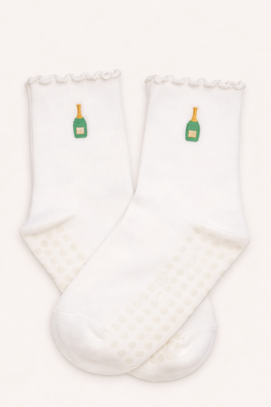 White embroidered Pilates grip socks featuring a champagne bottle design with non-slip soles, ruffled ankle detail, and breathable fabric, perfect for Pilates, barre, yoga, and studio workouts.