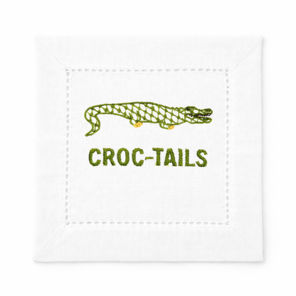 Embroidered cocktail napkin with green alligator design and “Croc-Tails” text, white linen napkin for cocktail parties, bar carts, and Southern entertaining.