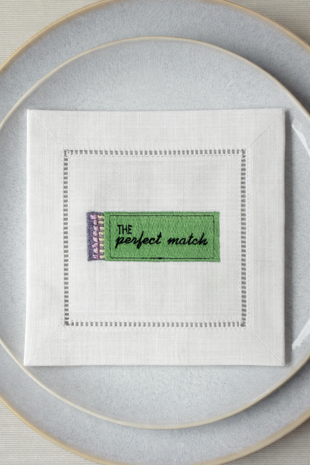 Embroidered cocktail napkin with “The Perfect Match” phrase, luxury linen napkin for entertaining and gifting.